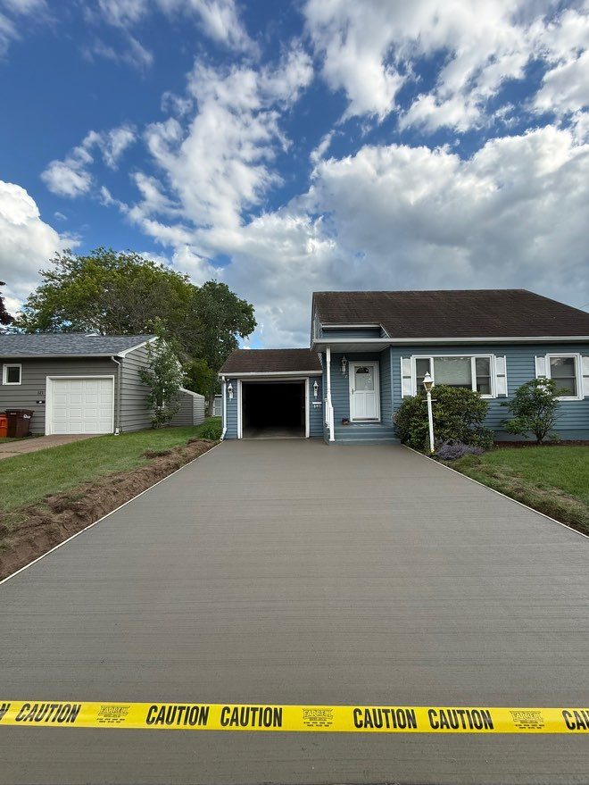 The same driveway replaced with new concrete, caution tape across the street end