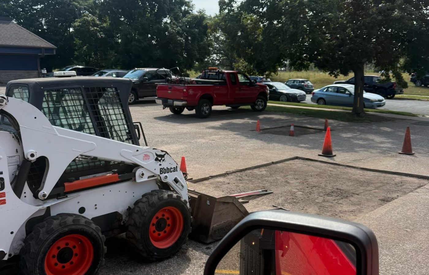Saw-cut asphalt patching in progress on a commercial lot